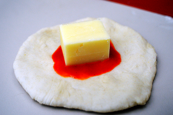 cheese with buffalo sauce on dough