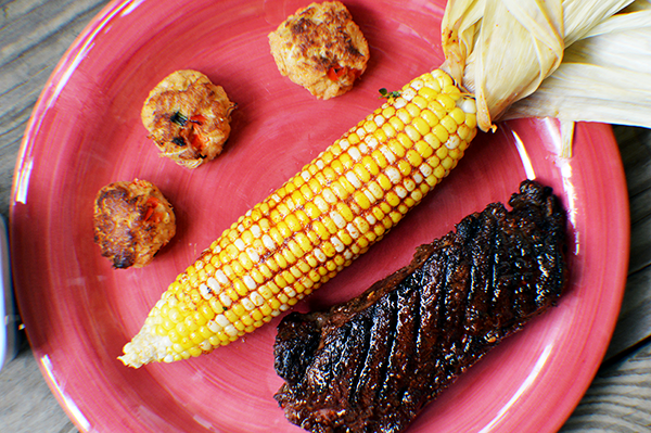 plated corn on the cob with steak and crab cakes