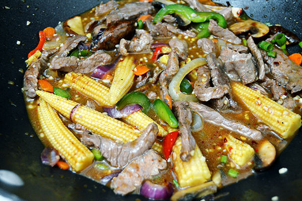 sauting veggies and meat in wok