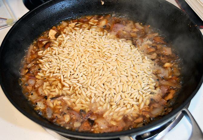 orzo in a pan with mushrooms