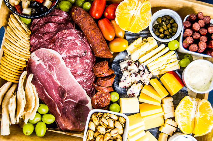 meat and cheese board with grape and fruit