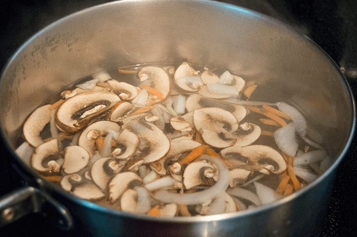 boiling mushrooms and carrots with onions